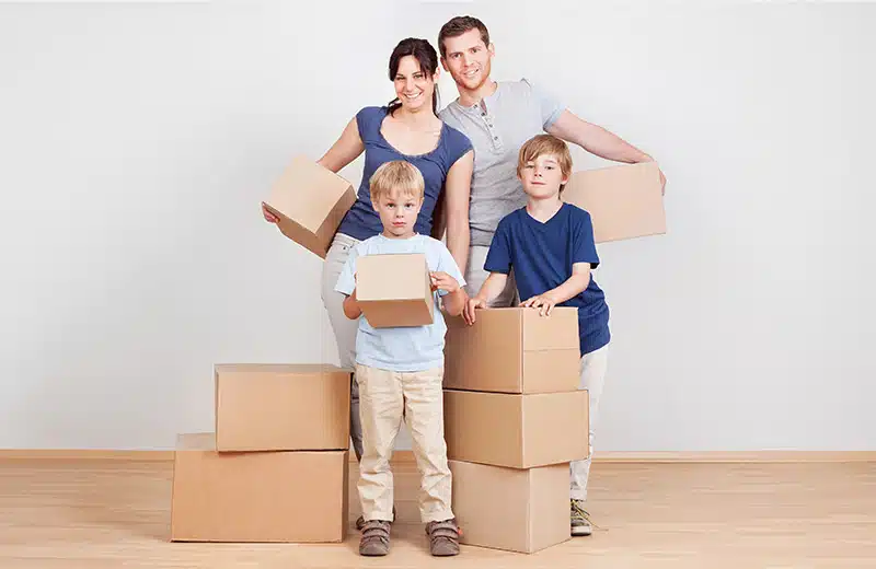 Happy family posing with furniture removal boxes.